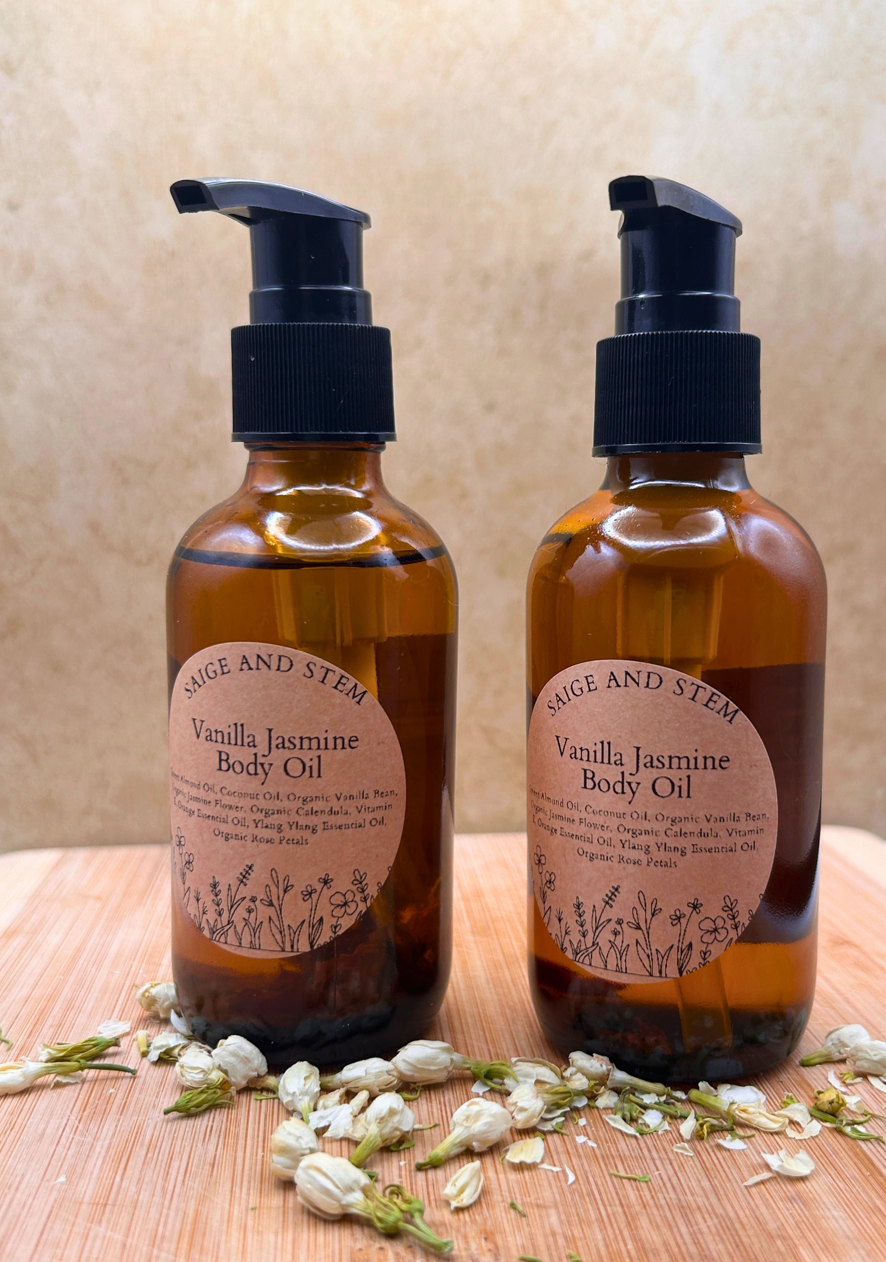 Vanilla Jasmine Body Oil in amber bottles with floral accents and pump dispensers, featuring calendula and jasmine.