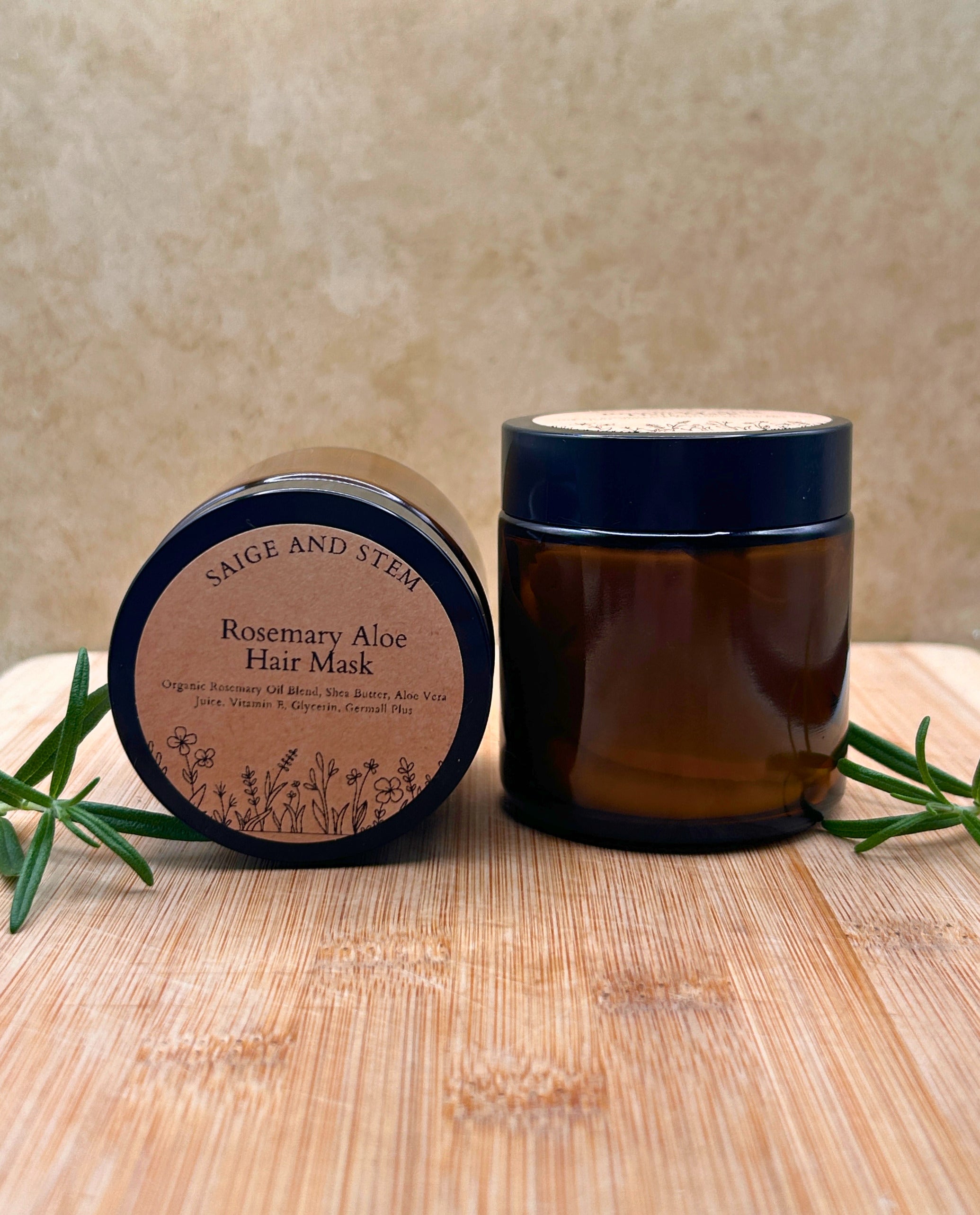 Rosemary Aloe Hair Mask in a dark amber jar with a botanical label, surrounded by fresh rosemary sprigs.
