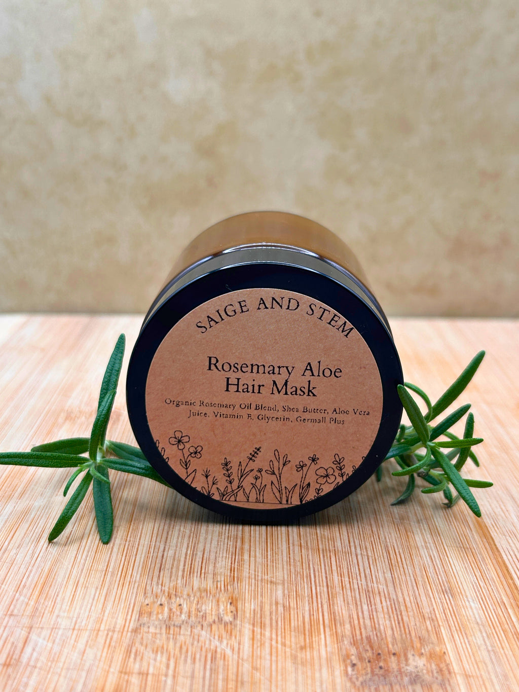 Rosemary Aloe Hair Mask in a dark jar with a label featuring botanical illustrations and rosemary sprigs.