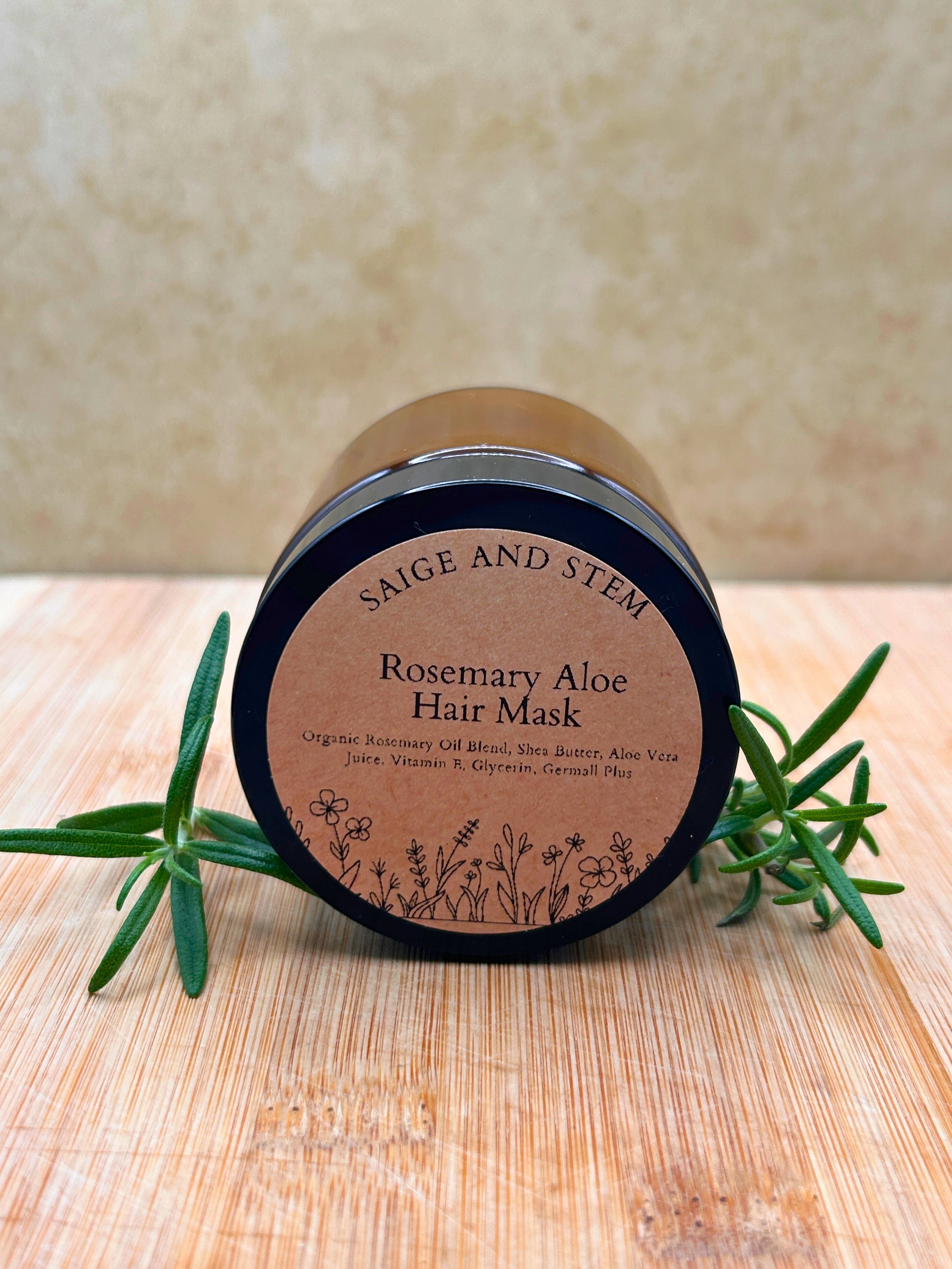 Rosemary Aloe Hair Mask in a dark jar with a label featuring botanical illustrations and rosemary sprigs.