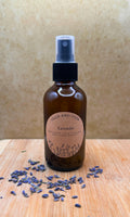Lavender Ritual Mist in a brown glass bottle with a label, surrounded by dried lavender flowers.
